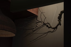 Modern interior design featuring metallic tree twigs on wall