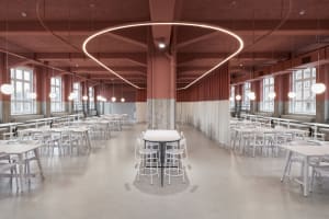 An empty, industrial-style cafeteria with white tables and chairs, concrete flooring, and circular lighting fixtures.