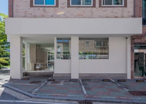 A modern coffee shop exterior with glass and concrete materials.