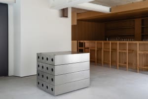 A modern metal counter bar with a minimalist design, featuring industrial-style metal boxes arranged in a cube-like structure