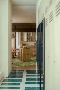 Modern kitchen with wooden cabinets and a green marble floor.