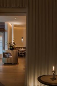 Modern restaurant interior with white curtains and wooden flooring.