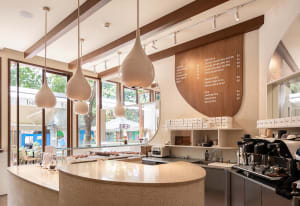 A modern coffee shop with a sleek, curved countertop and minimalist design.