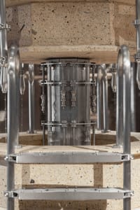 An industrial machine with metallic components and a concrete base.