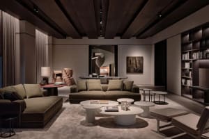 A spacious modern living room featuring two plush green sofas and several white round coffee tables.