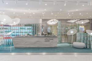 Modern retail storefront with concrete walls, glass displays, and illuminated light fixtures.