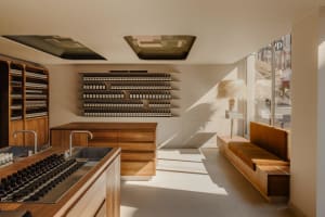 A minimalist storefront with wooden furniture and glass shelves.