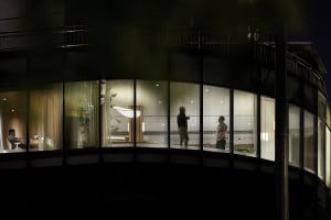 A modern residential interior featuring large glass windows with a dark exterior.