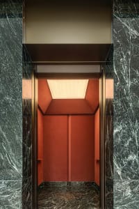 Modern lobby with marble walls and red leather seating