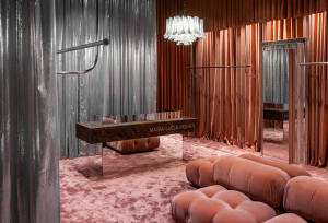 A modern fashion retail store featuring metallic textiles and a futuristic design.