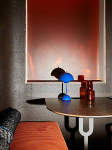 A modern interior featuring a metal table with a glass top and wooden legs.
