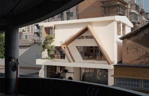 A modern urban residential house with concrete exterior and glass windows.