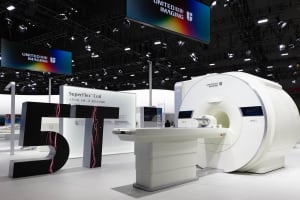 A modern medical device exhibit showcasing a white MRI machine with a futuristic design.