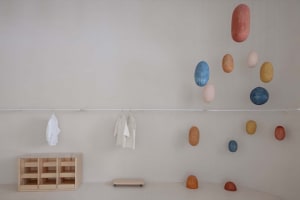 A modern retail storefront with hanging abstract shapes and minimalist furniture.