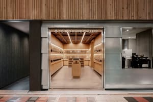 A modern retail storefront with wooden interior design and a display of knives under bright lighting.