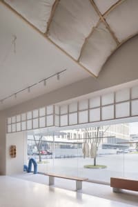 Minimalist retail store with fabric installations and glazed windows