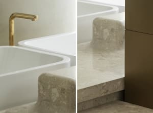 Modern minimalist bathroom with white terrazzo tiles and gold faucet.