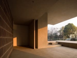 A minimalist building interior featuring concrete columns and a natural light-filled space.