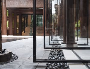 Modern interior design featuring glass looby with stone flooring and minimalist decor.