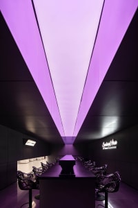 Modern industrial bar with metallic furniture and purple lighting