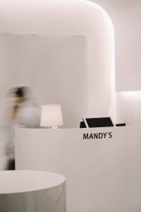 A minimalist spa reception desk made of white marble, featuring a sleek, modern design with clean lines and a simple, elegant