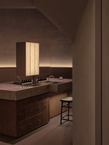 Minimalist bathroom with concrete countertops and industrial lighting.