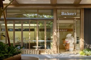 A bakery storefront with wooden architectural elements and a chef mascot.