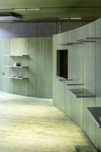 A modern interior space with concrete walls and shelves.