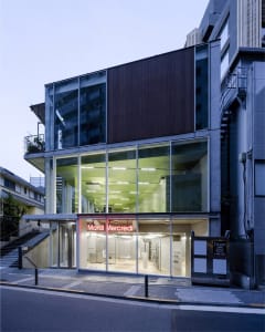 A modern storefront with a glass exterior during dusk