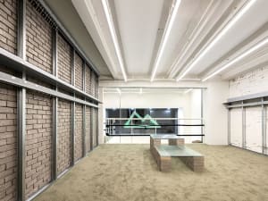A modern office space featuring concrete flooring and walls.