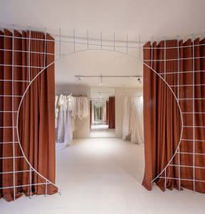 Retail storefront with fabric walls and metal frames in a metaverse setting.