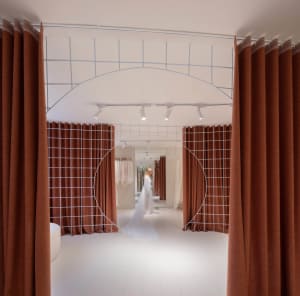 A modern retail interior featuring a transparent dress with fabric material and a metal grid structure.