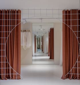 A modern retail interior designed for a clothing store, featuring fabric and metal materials, with an open space layout and c