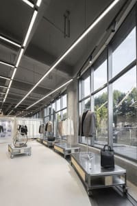 Retail shop interior with metal counters and clothing displays.