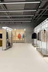A modern retail interior with metal hooks showcasing clothing items.
