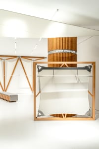 A minimalist storefront with a white space and wooden structures.
