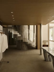 A modern residential interior featuring concrete and glass materials.