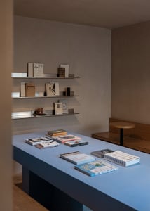 A modern bookstore with metal shelves displaying various books.