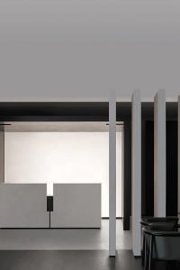 Photograph of a modern office interior with concrete walls and minimal furniture.