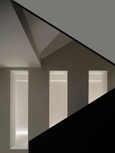 A minimalist design with concrete walls and a black floor.