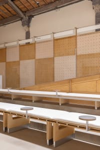 A modern interior space featuring a long wooden bench with white seating.