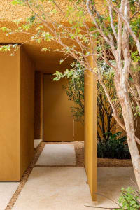 A modern house exterior featuring warm, earth-toned colors and natural elements.