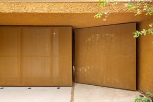 Metallic sliding gates in a contemporary exterior design.