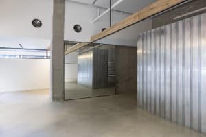 A minimalist showroom with metallic walls and polished concrete floor.