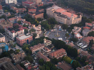 Aerial view of a bustling urban center with concrete buildings and a central plaza.