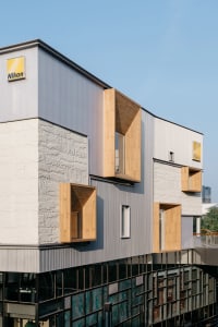 A modern office building with metal, stone, and wooden elements.