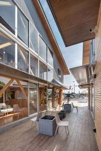 A modern exterior with glass walls and a wooden roof.