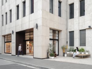 A sleek, contemporary retail storefront featuring concrete architecture and a minimalist aesthetic.