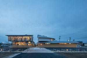 Modern commercial space featuring steel and glass architecture with illuminated interiors.