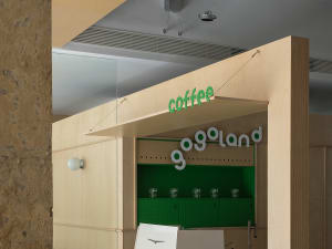 Modern coffee shop interior featuring wooden paneling and green accents.